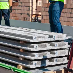 Strop betonowy w transporcie. Betonowe płyty stropowe ułożone na przyczepie, gotowe do montażu.