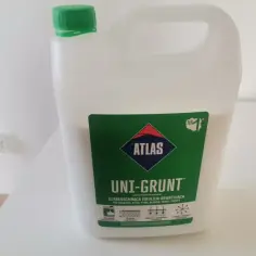 Biały kanister z zieloną etykietą "ATLAS UNI-GRUNT". Szybkoschnąca emulsja gruntująca, idealna do przygotowania podłoża. Sprawdź, ile schnie unigrunt przed dalszymi pracami.