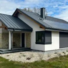 Nowy, nowoczesny dom z panelami słonecznymi na dachu, kamienną elewacją i tarasem. Czekamy na pozwolenie na użytkowanie.