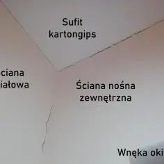 Widoczne pęknięcia na suficie karton-gips i ścianach, wskazujące na osiadanie budynku.
