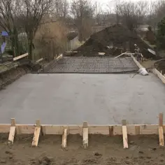 Plac budowy z wylana płytą fundamentową z betonu C25/30, zbrojenie czeka na zalanie.