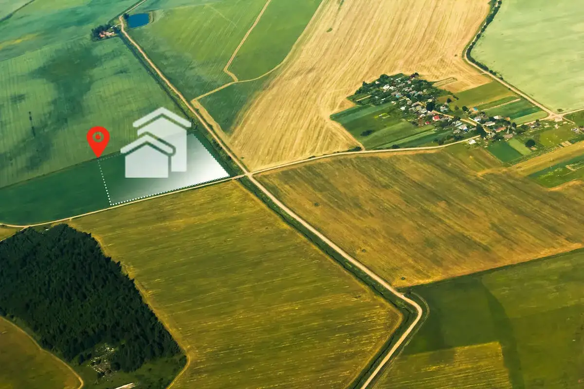 Działka rolna z warunkami zabudowy, oznaczona ikoną domu, otoczona polami uprawnymi i lasem.