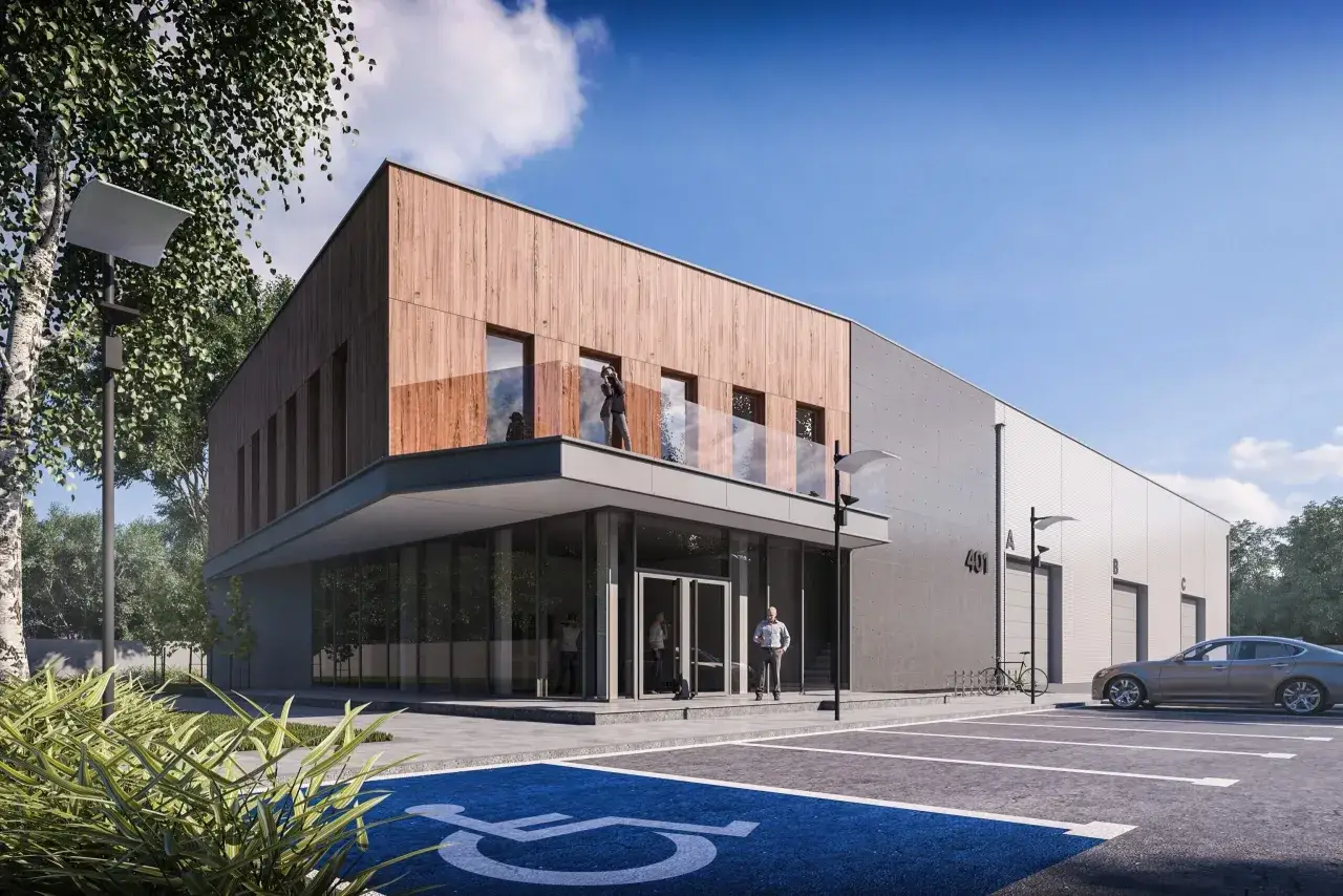 Nowoczesna budowa hali magazynowej z drewnianą elewacją i betonem. Przed budynkiem parking z miejscem dla niepełnosprawnych, samochód i rower.