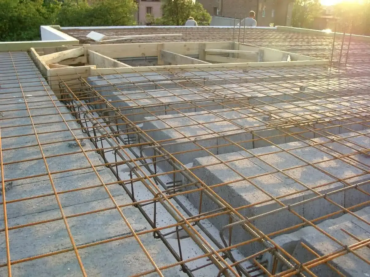 Szalowanie stropu zbrojonego, gotowe do zalania betonem. Widoczne pustaki szalunkowe i siatka z prętów.